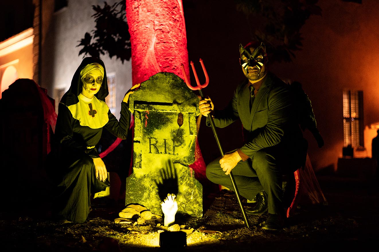 Uomo vestito da diavolo e suora posseduta vicino a lapide al Castello di San Giorgio Canavese per Halloween